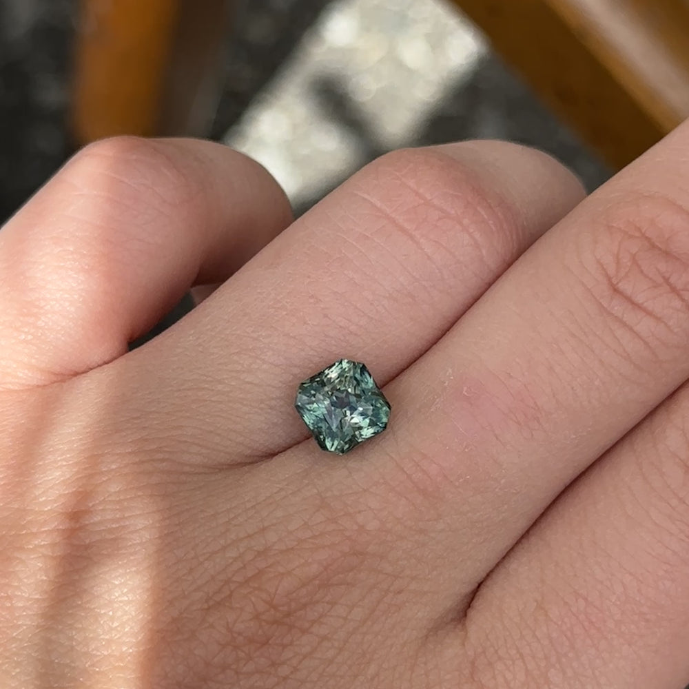 
                      
                        Load and play video in Gallery viewer, Create the ring of your dreams with this mesmerizing 3.40ct asscher cut teal sapphire. This utterly stunning unheated gemstone catches tones of aqua-teal and green within its facets, making it a truly one-of-a-kind gemstone.
                      
                    