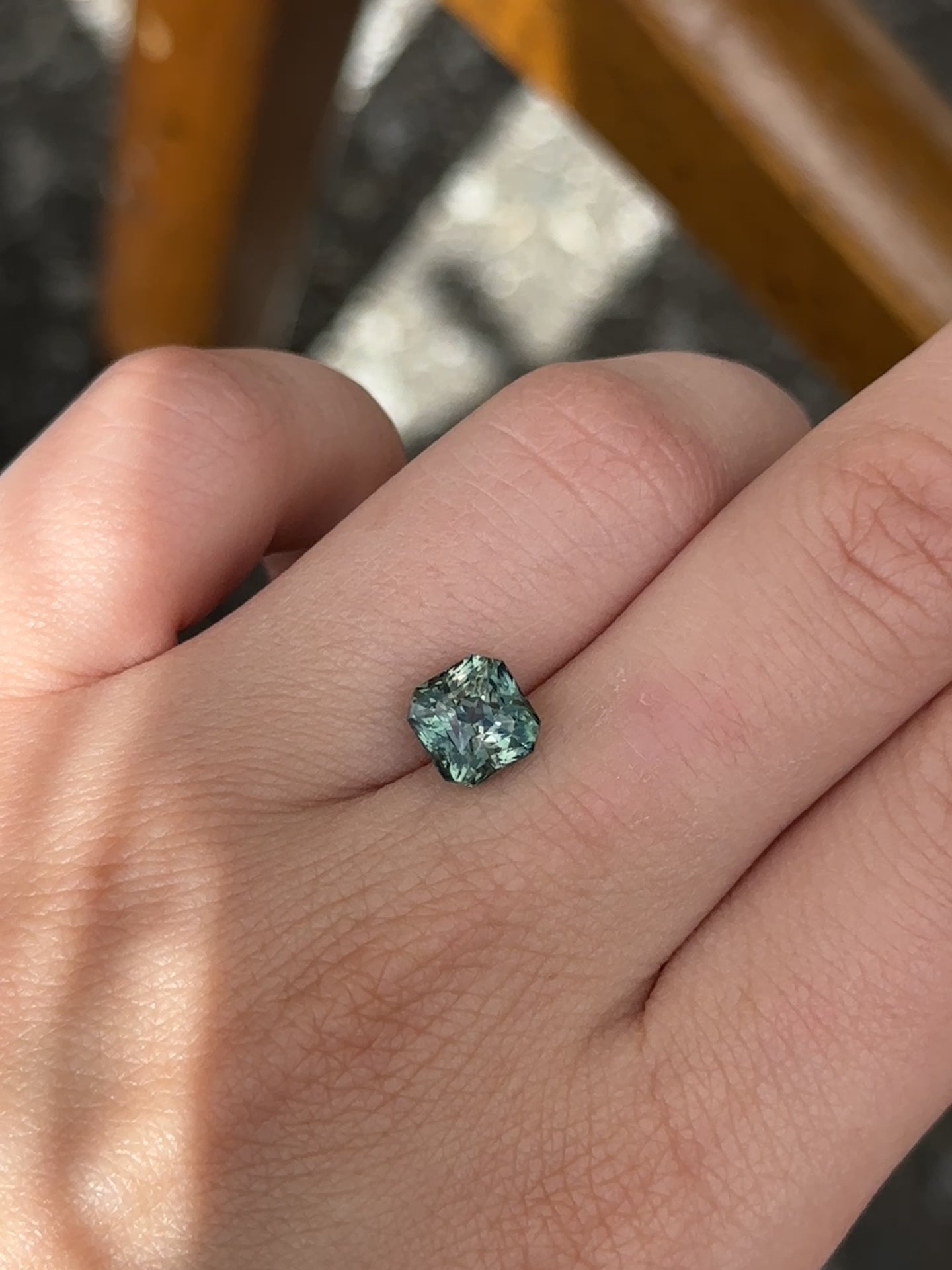 Create the ring of your dreams with this mesmerizing 3.40ct asscher cut teal sapphire. This utterly stunning unheated gemstone catches tones of aqua-teal and green within its facets, making it a truly one-of-a-kind gemstone.