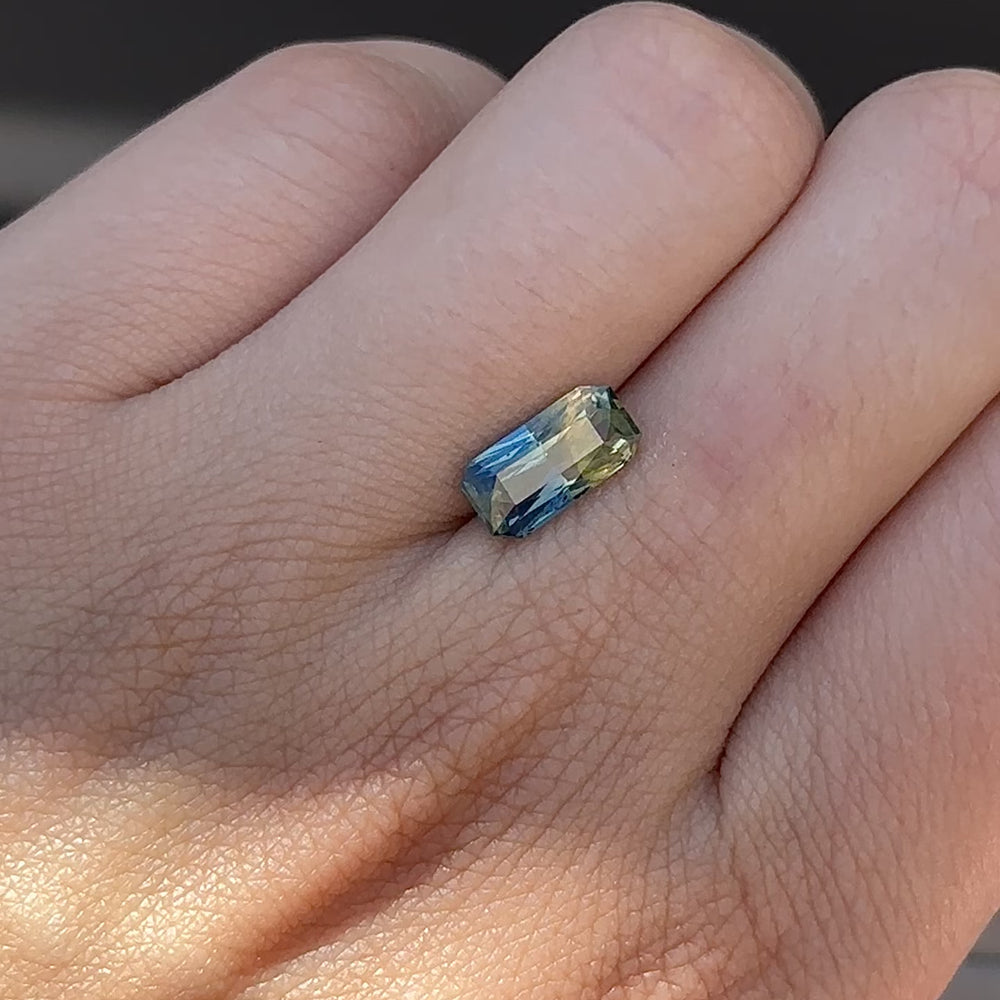 
                      
                        Load and play video in Gallery viewer, Create the ring of your dreams with this 2.26ct emerald-cut Madagascar bi-colour sapphire. This utterly stunning gemstone catches an alluring deep tone of blue and vibrant yellow tones within its facets, making it truly one-of-a-kind.
                      
                    