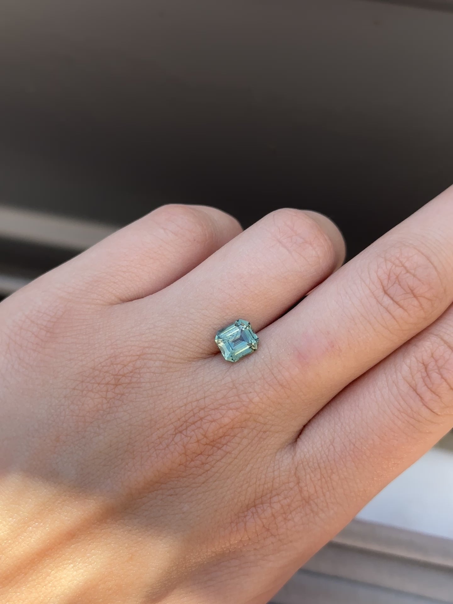 Create the ring of your dreams with this 2.10ct asscher cut teal sapphire. This utterly stunning gemstone holds an alluring tone of aqua teal and vibrant green within its facets, making it truly one-of-a-kind.