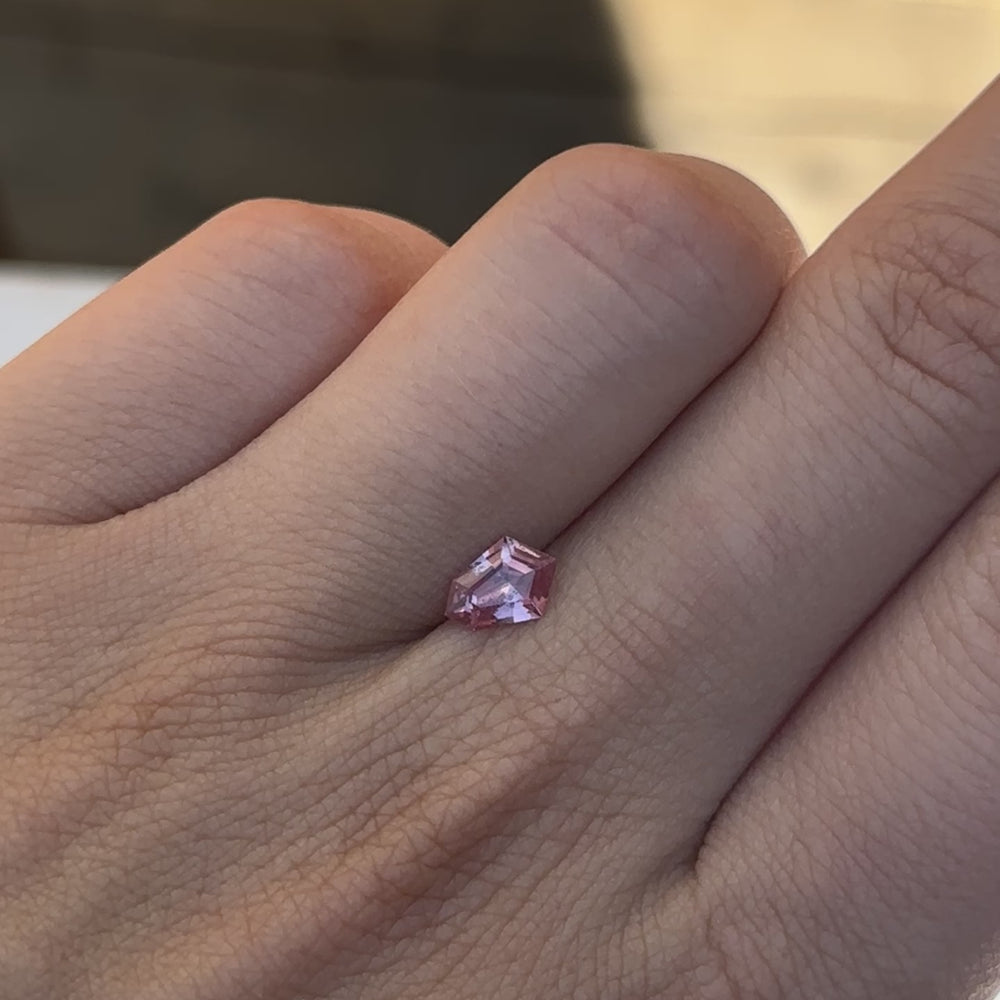 
                  
                    Load and play video in Gallery viewer, Discover the allure of this utterly exquisite 0.71ct geometric sapphire, perfect for becoming the centrepiece of your dream jewelry. Its mesmerizing facets capture rich peach and pink tones, making it an exceptional and unique gemstone.
                  
                