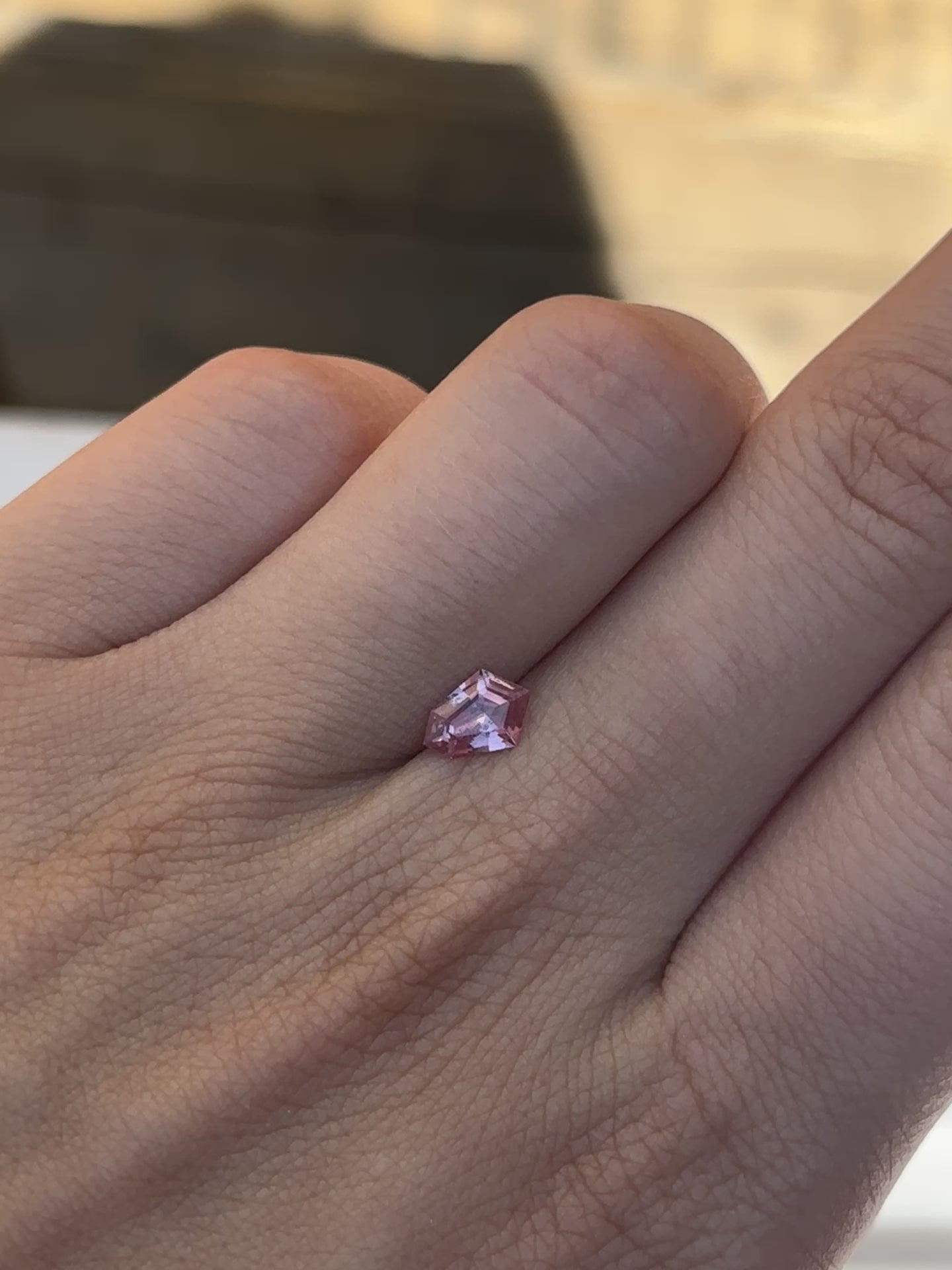 Discover the allure of this utterly exquisite 0.71ct geometric sapphire, perfect for becoming the centrepiece of your dream jewelry. Its mesmerizing facets capture rich peach and pink tones, making it an exceptional and unique gemstone.