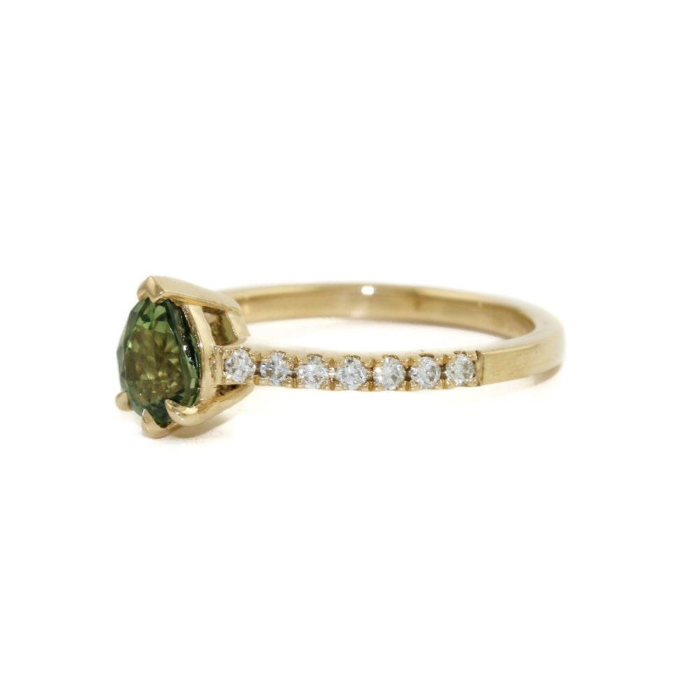 
                      
                        An alluring seafoam green sapphire, cut in the shape of a teardrop to flatter and elongate the finger. This beautiful stone is set in a 14k gold bezel, surrounded by brilliant tiny diamonds.
                      
                    