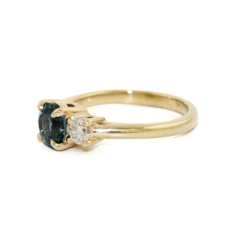 
                      
                        This exquisite ring features a mesmerizing dark blue Montana sapphire, carefully cut and polished to bring out the best of its natural radiance and captivating colour. The sapphire is perfectly complemented by the sparkling diamonds set in the 14k gold band, creating an unforgettable display of brilliance and elegance.
                      
                    