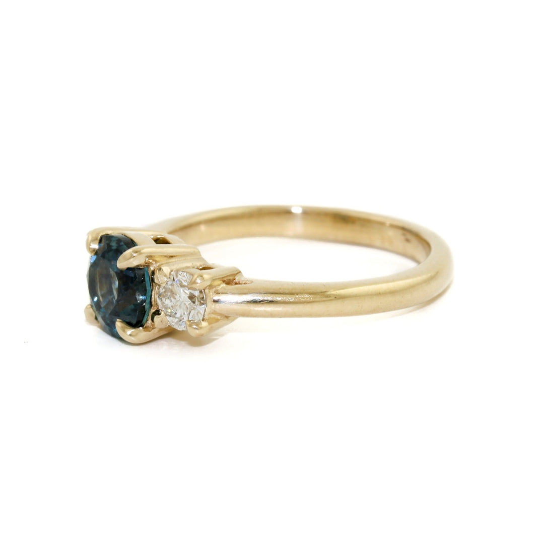 This exquisite ring features a mesmerizing dark blue Montana sapphire, carefully cut and polished to bring out the best of its natural radiance and captivating colour. The sapphire is perfectly complemented by the sparkling diamonds set in the 14k gold band, creating an unforgettable display of brilliance and elegance.