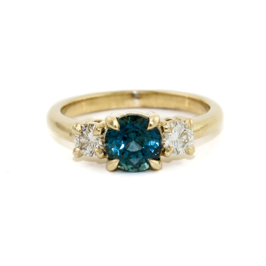 This exquisite ring features a mesmerizing dark blue Montana sapphire, carefully cut and polished to bring out the best of its natural radiance and captivating colour. The sapphire is perfectly complemented by the sparkling diamonds set in the 14k gold band, creating an unforgettable display of brilliance and elegance.