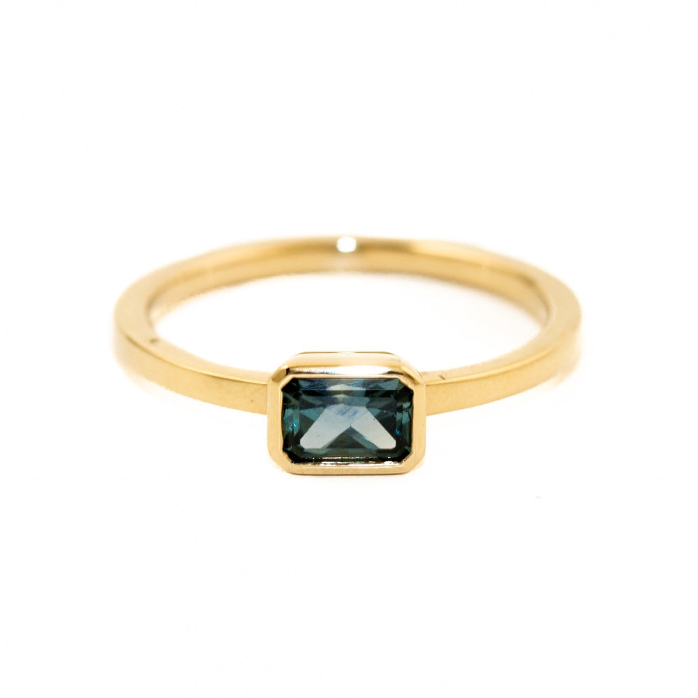 Gorgeous classic sapphire ring made by Kingdom. The emerald cut Montana sapphire is held in a claw 14 karat gold setting. Crafted with passion and detail in-mind, our new 