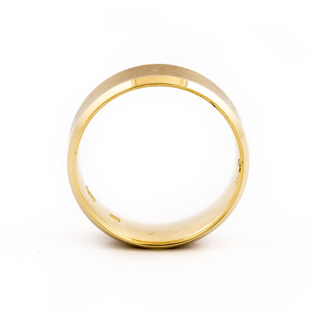 This clean modern ring is a refined and contemporary wedding band, featuring a recessed edge contrasting a brushed and shiny edge. The textured angled design gives it a modern feel and makes for a comfortable ring.