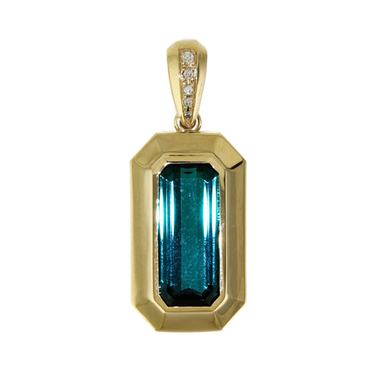 A deep moody green tourmaline pendant featuring an art deco-inspired 14k gold bezel.